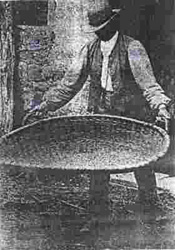 Altes Foto: Ein Mann mit einer Getreideschwinge