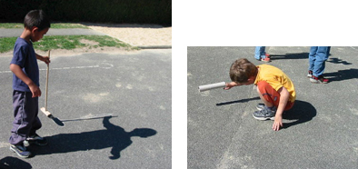 Foto: Junge mit einem Besen in der Hand und hockender Junge mit Papprolle